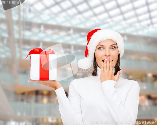 Image of smiling woman in santa helper hat with gift box