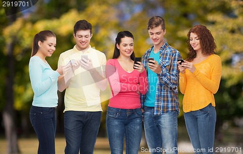 Image of group of smiling teenagers with smartphones