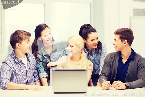 Image of smiling students with laptop at school