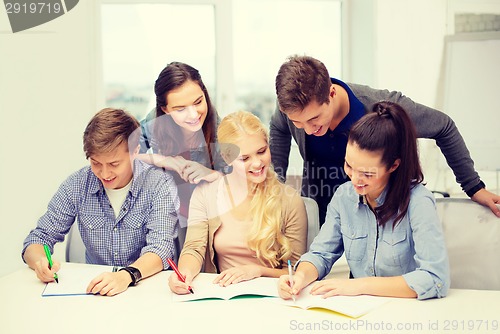 Image of smiling students with notebooks at school