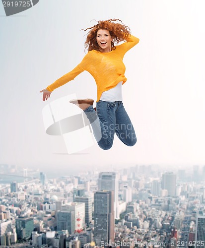 Image of smiling young woman jumping in air