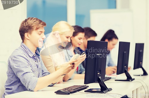 Image of students with computer monitor and smartphones