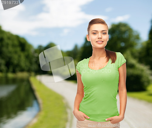 Image of smiling young woman in blank green t-shirt