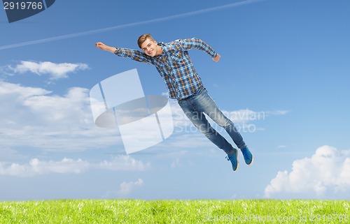 Image of smiling young man jumping in air