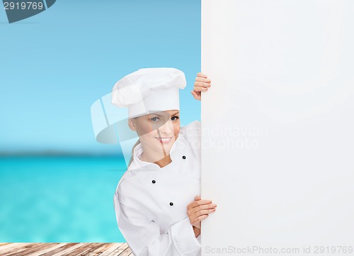 Image of smiling female chef with white blank board