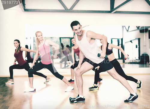 Image of group of smiling people working out with dumbbells