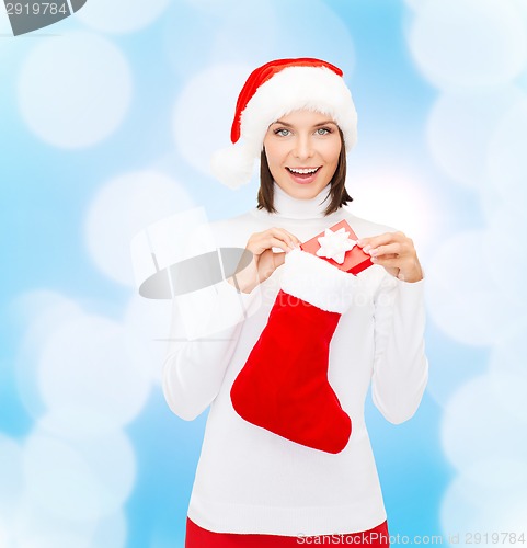 Image of woman in santa hat with gift box and stocking