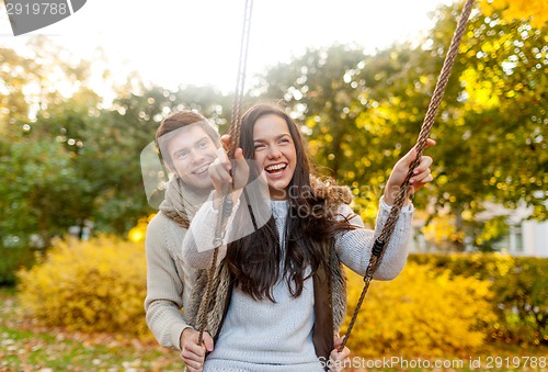 Image of smiling couple hugging in autumn park