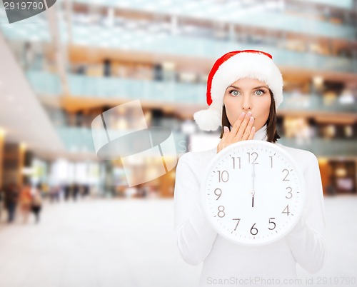 Image of woman in santa helper hat with clock showing 12