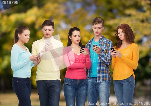 Image of group of serious teenagers with smartphones