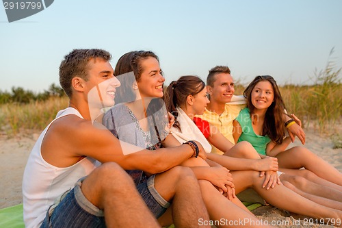 Image of smiling friends in sunglasses on summer beach