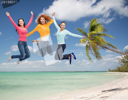 Image of group of smiling young women jumping in air