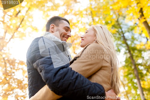 Image of smiling couple hugging in autumn park