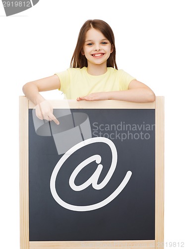 Image of smiling little girl pointing finger to blackboard