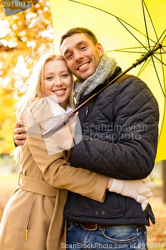 Image of smiling couple hugging in autumn park