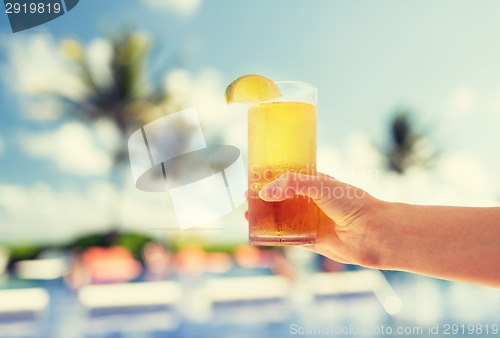 Image of close-up of hand holding glass with cocktail