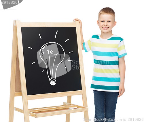 Image of smiling little boy with blank blackboard