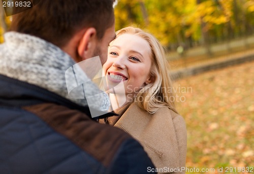 Image of smiling couple hugging in autumn park