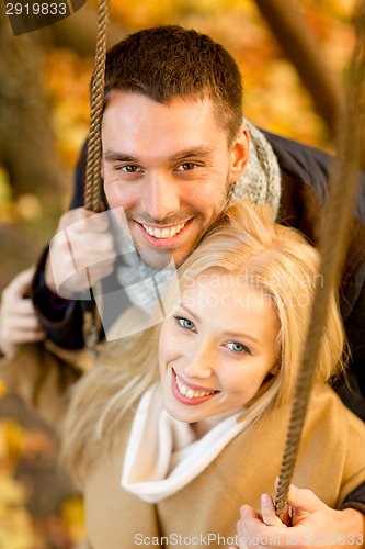 Image of smiling couple hugging in autumn park