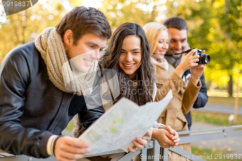 Image of group of friends with map and camera outdoors
