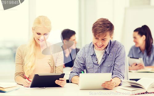 Image of two smiling students with tablet pc at school