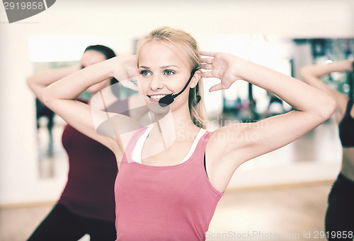 Image of group of smiling people exercising in the gym