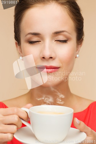 Image of smiling woman in red dress with cup of coffee