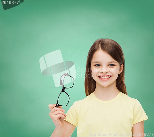 Image of smiling cute little girl holding black eyeglasses