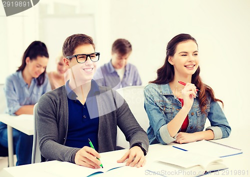 Image of smiling students with notebooks at school