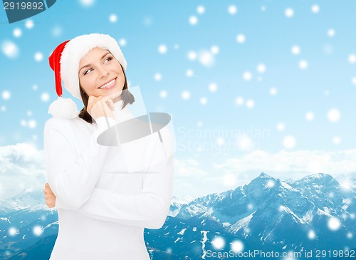 Image of thinking and smiling woman in santa helper hat