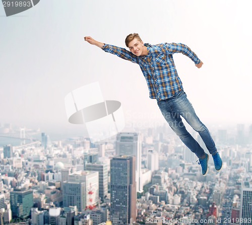 Image of smiling young man jumping in air