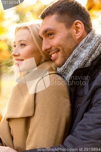 Image of smiling couple hugging in autumn park