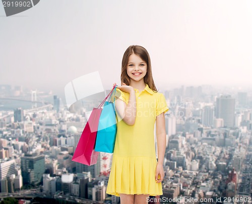 Image of smiling little girl in dress with shopping bags