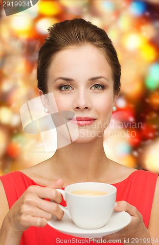 Image of smiling woman in red dress with cup of coffee