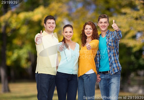 Image of group of smiling teenagers over green park