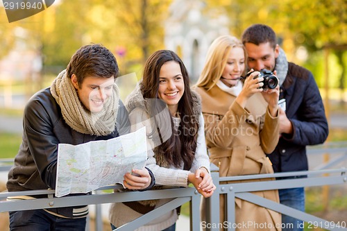 Image of group of friends with map and camera outdoors