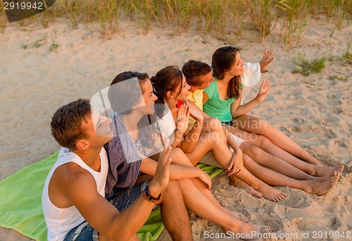 Image of smiling friends in sunglasses on summer beach