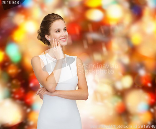 Image of smiling woman in white dress wearing diamond ring