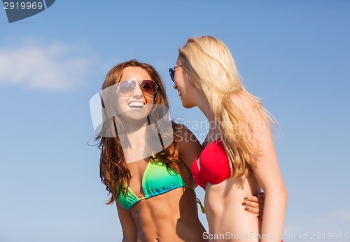 Image of two laughing young women on beach