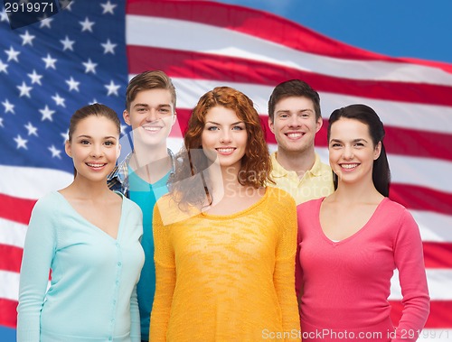 Image of group of smiling teenagers over american flag