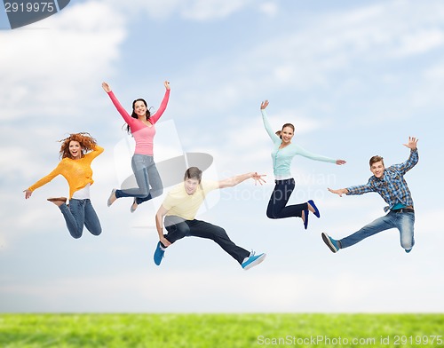 Image of group of smiling teenagers jumping in air