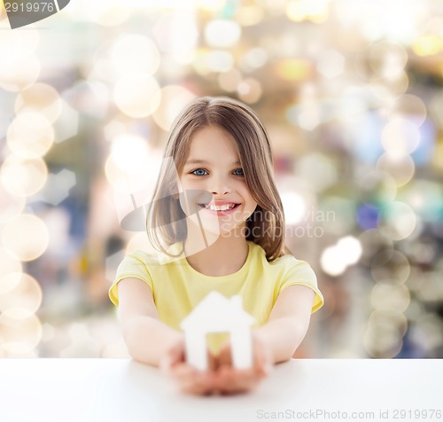 Image of beautiful little girl holding paper house cutout