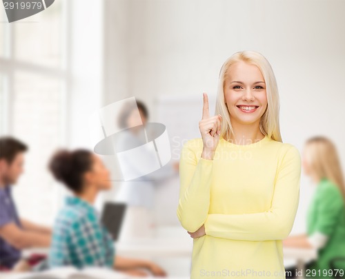 Image of smiling woman pointing her finger up