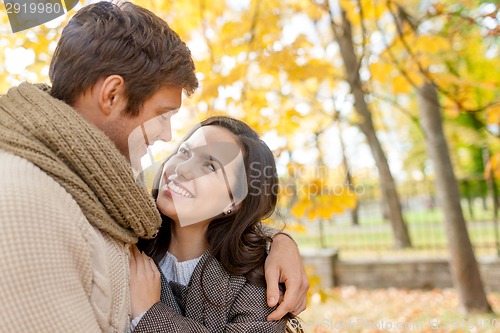 Image of smiling couple hugging in autumn park