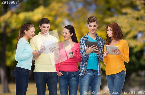 Image of group of teenagers with smartphones and tablet pc