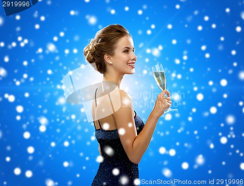 Image of smiling woman holding glass of sparkling wine