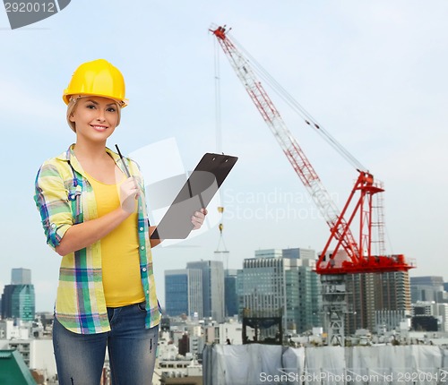 Image of smiling woman in helmet with clipboard