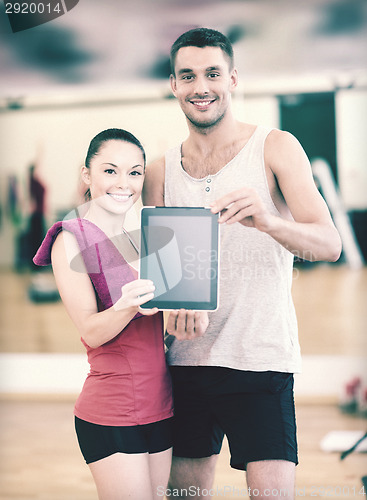 Image of two smiling people showing blank tablet pc screen