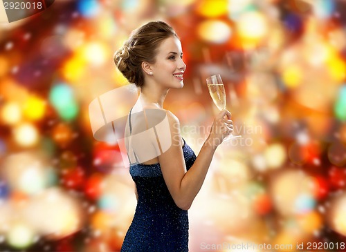 Image of smiling woman holding glass of sparkling wine