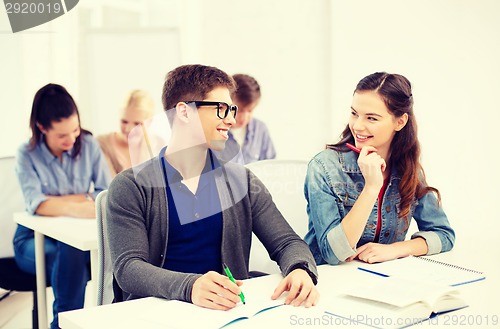 Image of smiling students with notebooks at school